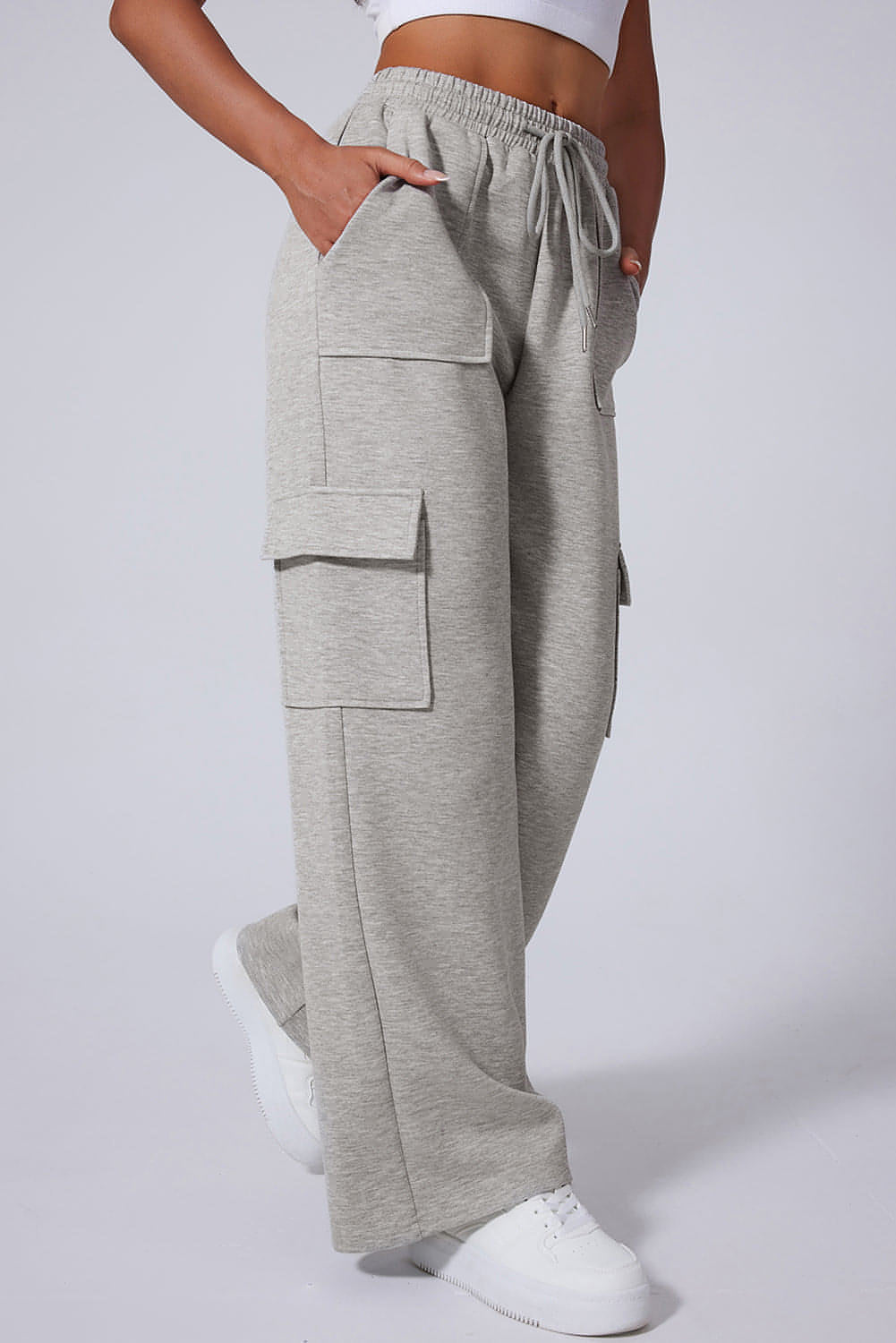 Pantalones de entrenamiento de cintura alta, pierna ancha y múltiples bolsillos con cordones en color gris claro