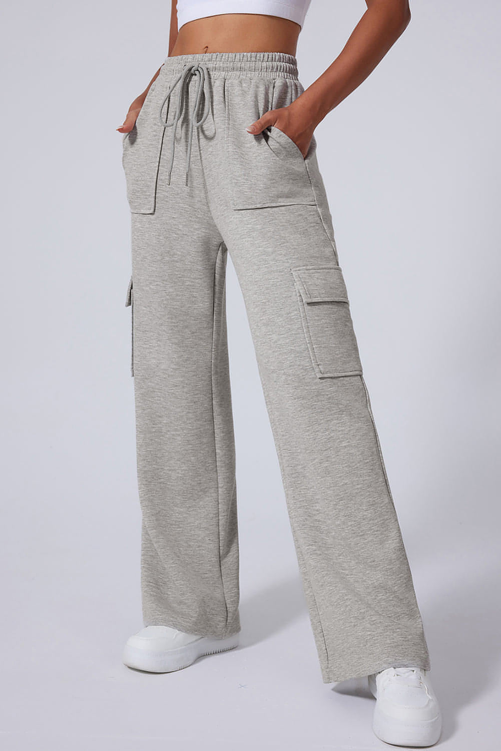 Pantalones de entrenamiento de cintura alta, pierna ancha y múltiples bolsillos con cordones en color gris claro