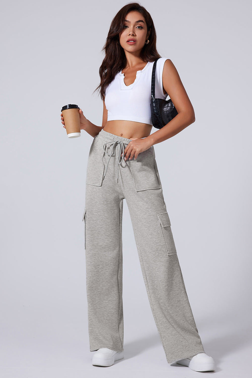 Pantalones de entrenamiento de cintura alta, pierna ancha y múltiples bolsillos con cordones en color gris claro